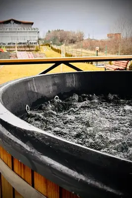 a bath tub filled with water next to a building at Къща за гости Касида in Sapareva Banya