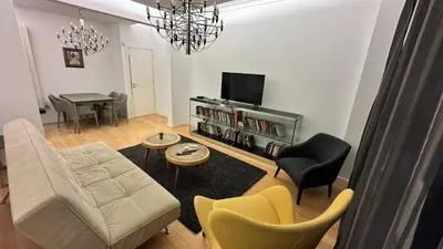 a living room with a couch and chairs and a tv at Bonnie's Stylsih 2BR Home near the Palace in Sofia