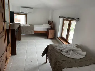 a small room with two beds and a window at Къща за гости Стиляна in Devin