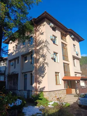 a large white building with trees in front of it at Къща за гости Стиляна in Devin