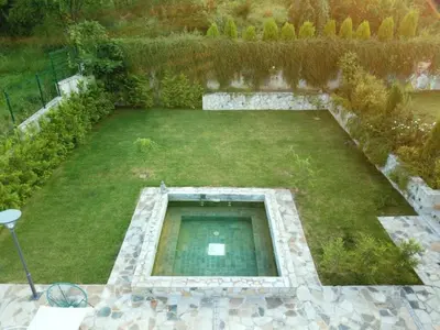 an aerial view of a garden with a pond at Къща за гости Стиляна in Devin