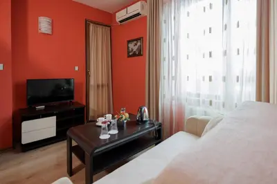 a living room with red walls and a couch and a tv at Trafi Em in Sofia