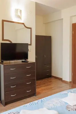 a bedroom with a dresser with a flat screen tv at Trafi Em in Sofia