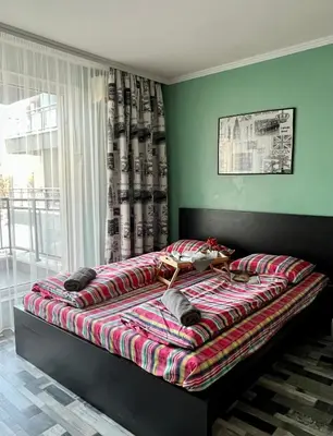 a bedroom with a large bed with a blanket on it at Flower home 2 in Sofia