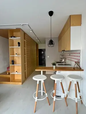 a kitchen with wooden cabinets and bar stools at Flower home 5 in Sofia