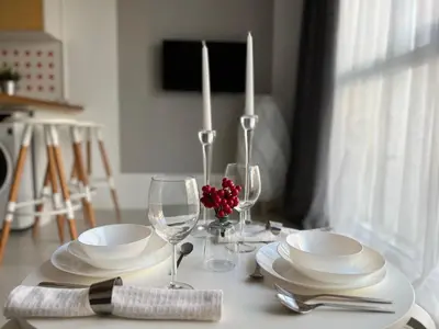 a table with white plates and wine glasses on it at Flower home 5 in Sofia