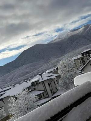 a snow covered city with mountains in the background at Deluxe Apartment in Bansko