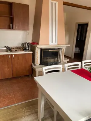 a kitchen with a table and a stove top oven at Вилно селище Баташки хан in Tsigov Chark