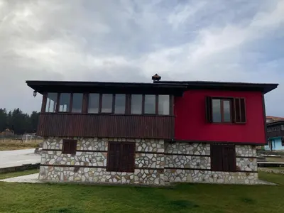 a house with a red roof and a stone facade at Вилно селище Баташки хан in Tsigov Chark