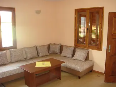 a living room with a couch and a table at Вилно селище Баташки хан in Tsigov Chark