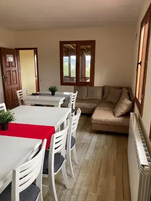 a living room with a couch and a table and chairs at Вилно селище Баташки хан in Tsigov Chark