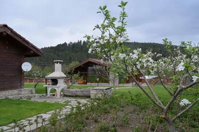 a garden with a white stove in front of a building at Gostnici Holiday Home in Razlog