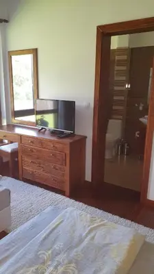 a bedroom with a tv and a dresser with a mirror at Gostnici Holiday Home in Razlog