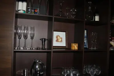 a shelf filled with wine glasses in a restaurant at The Stone Villa in Beli Iskar