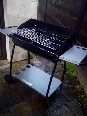 a grill sitting on the ground next to a table at The Stone Villa in Beli Iskar