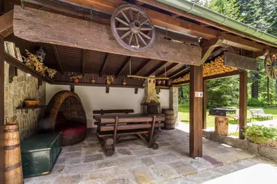 an outdoor patio with a wooden pizza oven and benches at Villa Kalia in Borovets