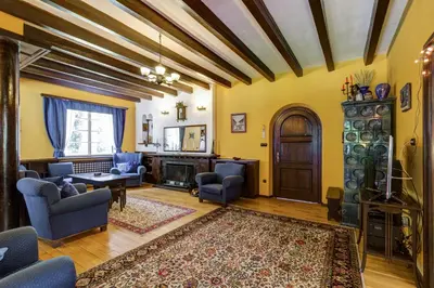 a living room with yellow walls and wooden ceilings at Villa Kalia in Borovets