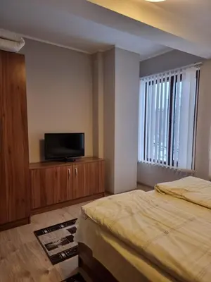 a bedroom with a bed and a tv on a wooden cabinet at Andreevite Houses in Sapareva Banya