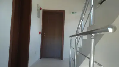 a hallway with a brown door and a stair case at Andreevite Houses in Sapareva Banya