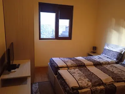 a hotel room with two beds and a window at Andreevite Houses in Sapareva Banya