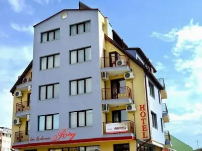 a white and yellow building with a sign on it at Ring Hotel in Blagoevgrad