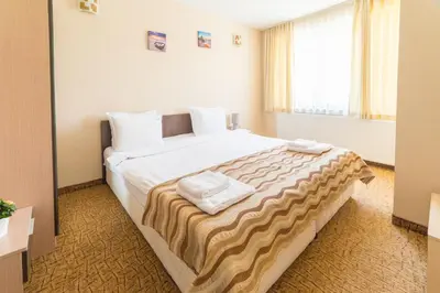 a bedroom with a large bed with two towels on it at Ring Hotel in Blagoevgrad