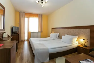 a hotel room with a large bed and a television at Villa Santa Maria in Tsigov Chark