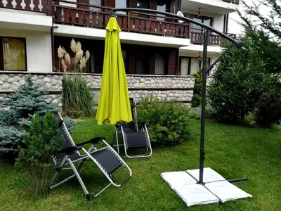 two chairs and a yellow umbrella in a yard at Apartments Elegance in Bansko