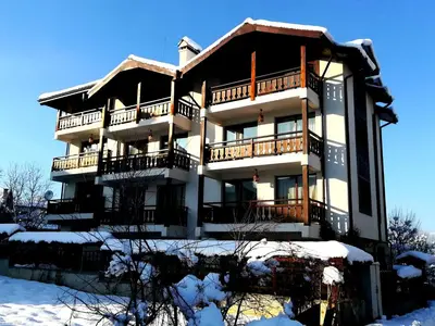a large building with snow on the ground at Apartments Elegance in Bansko