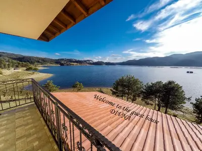 a view of a lake from a balcony at Divna Forest & Lake House in Dospat