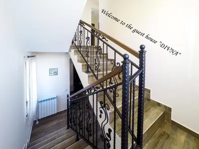 a staircase in a house with a sign on the wall at Divna Forest & Lake House in Dospat