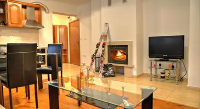 a living room with a glass table and a fireplace at Grand Monastery Pamporovo Apartment 5B23 in Pamporovo