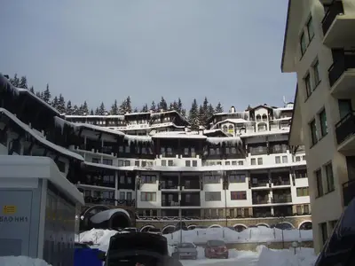 a large building with snow on top of it at Grand Monastery Pamporovo Apartment 5B23 in Pamporovo