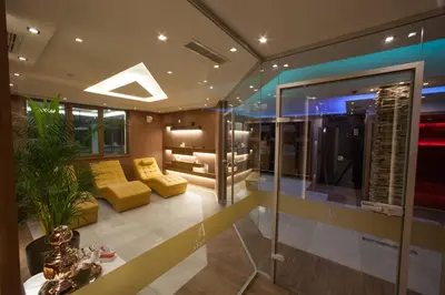 a living room with a yellow couch and a glass wall at Amira Boutique Hotel in Bansko