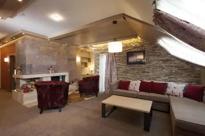 a living room with a couch and a brick wall at Amira Boutique Hotel in Bansko