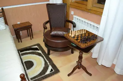 a room with a chair and a chessboard on a table at Guest House Secession Style in Sofia