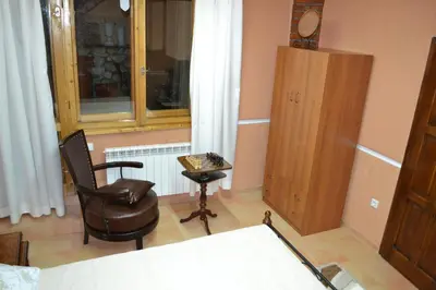 a room with a chair and a stool and a window at Guest House Secession Style in Sofia