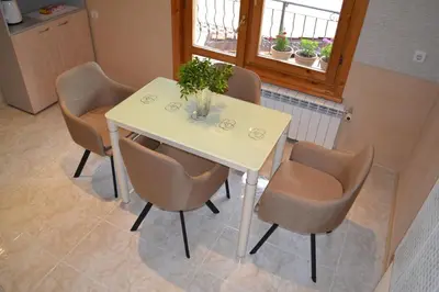 a white table with four chairs and a window at Guest House Secession Style in Sofia
