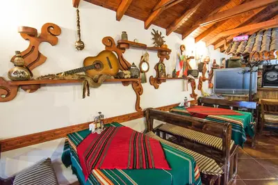 a dining room with two tables and a tv at Family Hotel Victoria Gold in Mineralni Bani