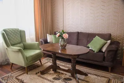 a living room with a couch and a table and a chair at Family Hotel Victoria Gold in Mineralni Bani