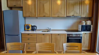 a kitchen with wooden cabinets and a table and chairs at Pirin Nest Villa in Bansko