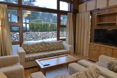 a living room with couches and a flat screen tv at Pirin Nest Villa in Bansko
