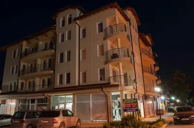 a tall building with cars parked in front of it at Apartment Elegant in Velingrad