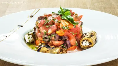 a white plate of food with mushrooms and vegetables at Hotel Sani in Asenovgrad