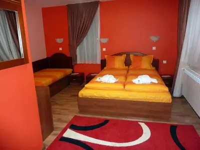 a bedroom with a bed and a red wall at Guest House H Dzhogolanov in Koprivshtitsa