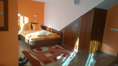 a bedroom with a bed and a cabinet and a rug at Guest House H Dzhogolanov in Koprivshtitsa