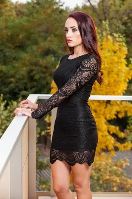 a woman in a black dress standing on a railing at Victoriya's House in Hisarya