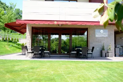 a restaurant with tables and chairs in front of a building at Victoriya's House in Hisarya