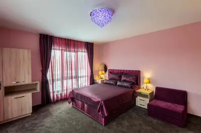a bedroom with a purple bed and a chair at Victoriya's House in Hisarya
