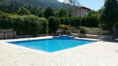 a swimming pool in a yard with a house at Holiday House Kubrat in Sapareva Banya